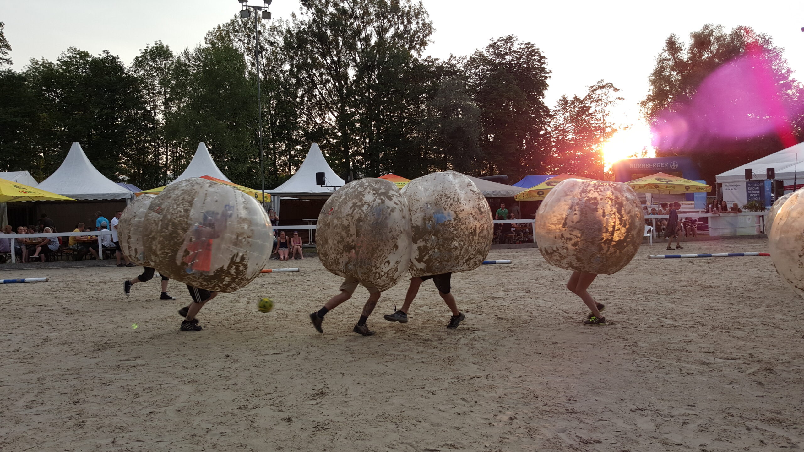 Bubble Soccer gespielt auf Sand bei einer Firmenfeier