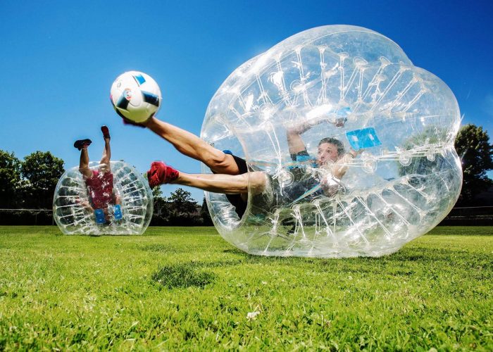 Bubble Soccer - Kugelz, close up ein mann tritt den Fußball