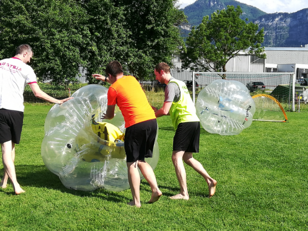 Männer rollen Bräutigam am Junggesellenabschied in Bubble Soccer Ball